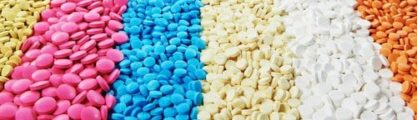 A pile of antibiotic pills in different colours.