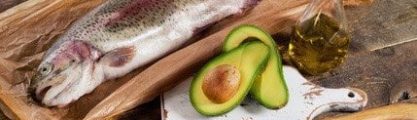 fish, avocado, walnuts laid out on a wooden board