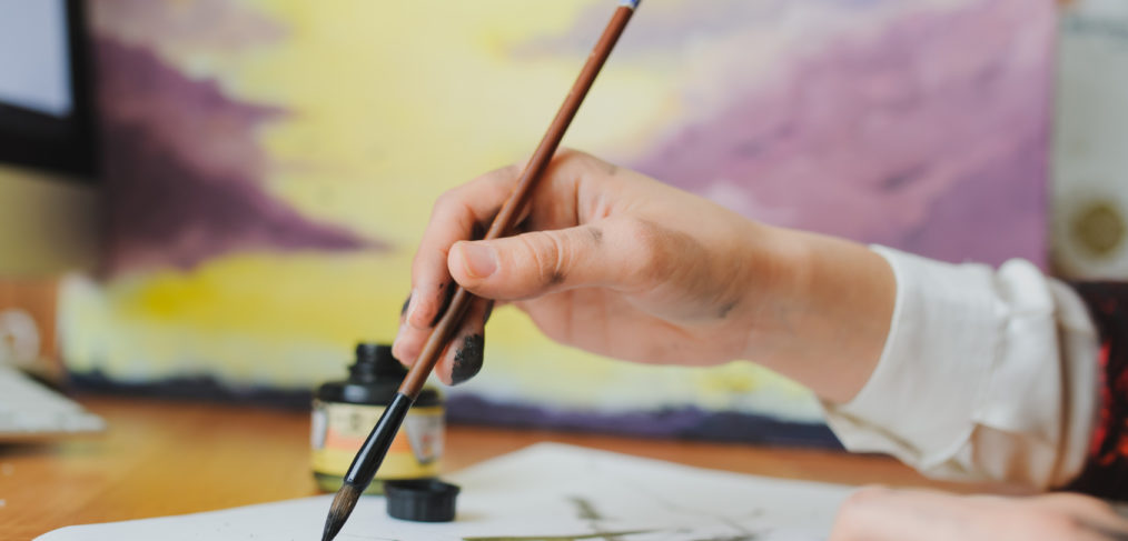 A hand writing chinese calligraphy with ink.