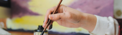 A hand writing chinese calligraphy with ink.