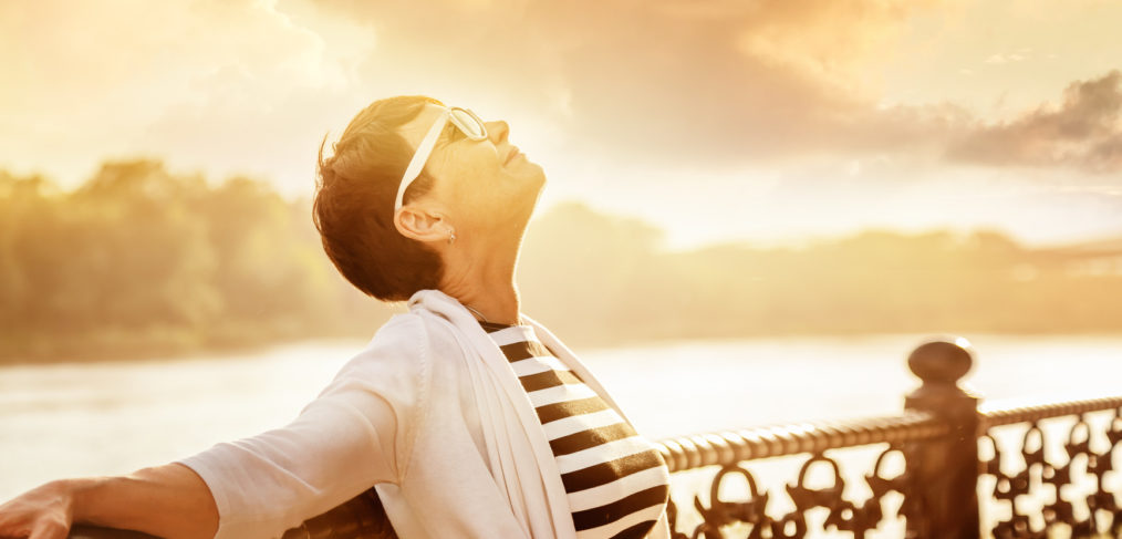 Portrait of a happy attractive mature senior woman 50 years old at sunset