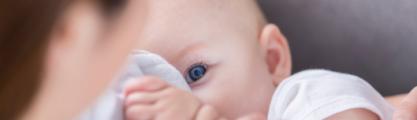 A lady with blue nail polish breastfeeding a baby