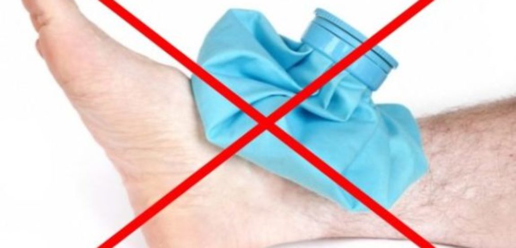Foot with a blue ice bag on it with a big red cross through the whole image